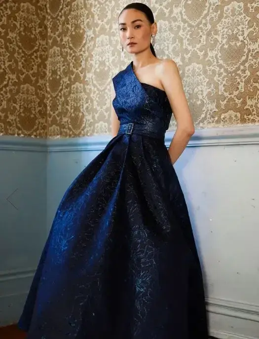 Sacha Drake model in a navy one-shoulder occasion gown